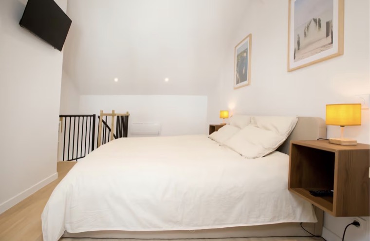 Chambre en mezzanine rénovée avec lit blanc