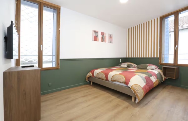 Chambre rénovée avec soubassement vert et mobilier bois