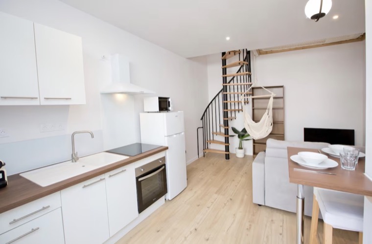 Cuisine ouverte et séjour rénovés avec escalier