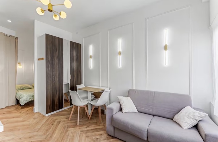 Salon rénové avec moulures murales et appliques lumineuses
